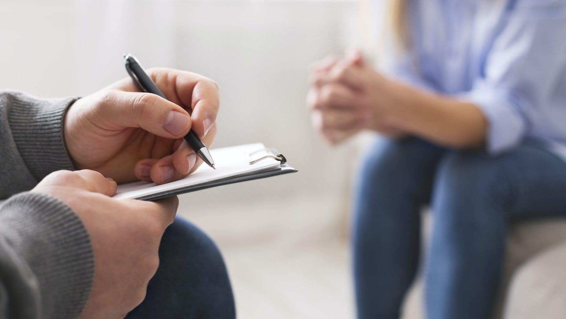 Psychologist noting problems of patient at therapy session